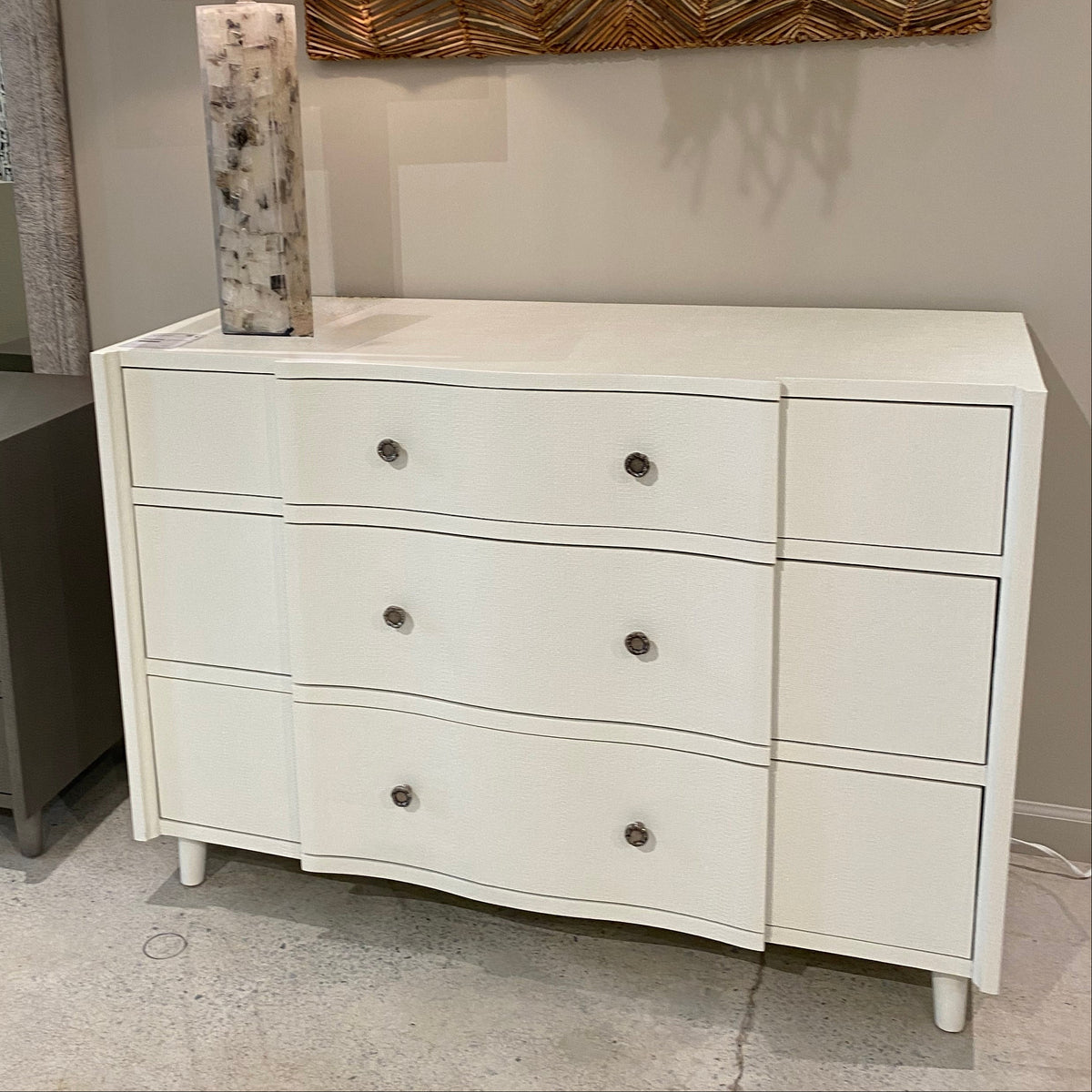 White dresser with gray lamp in a room setting