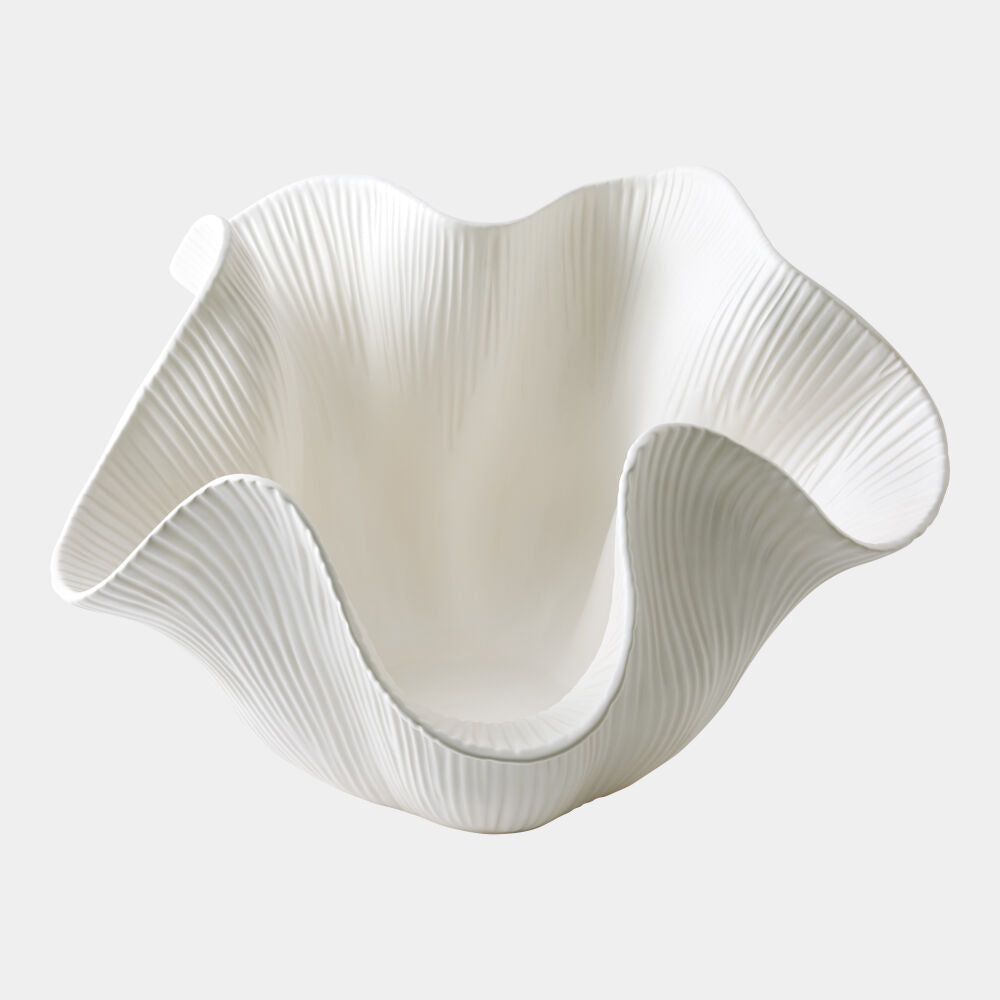 White ceramic vase with wavy design on a white background