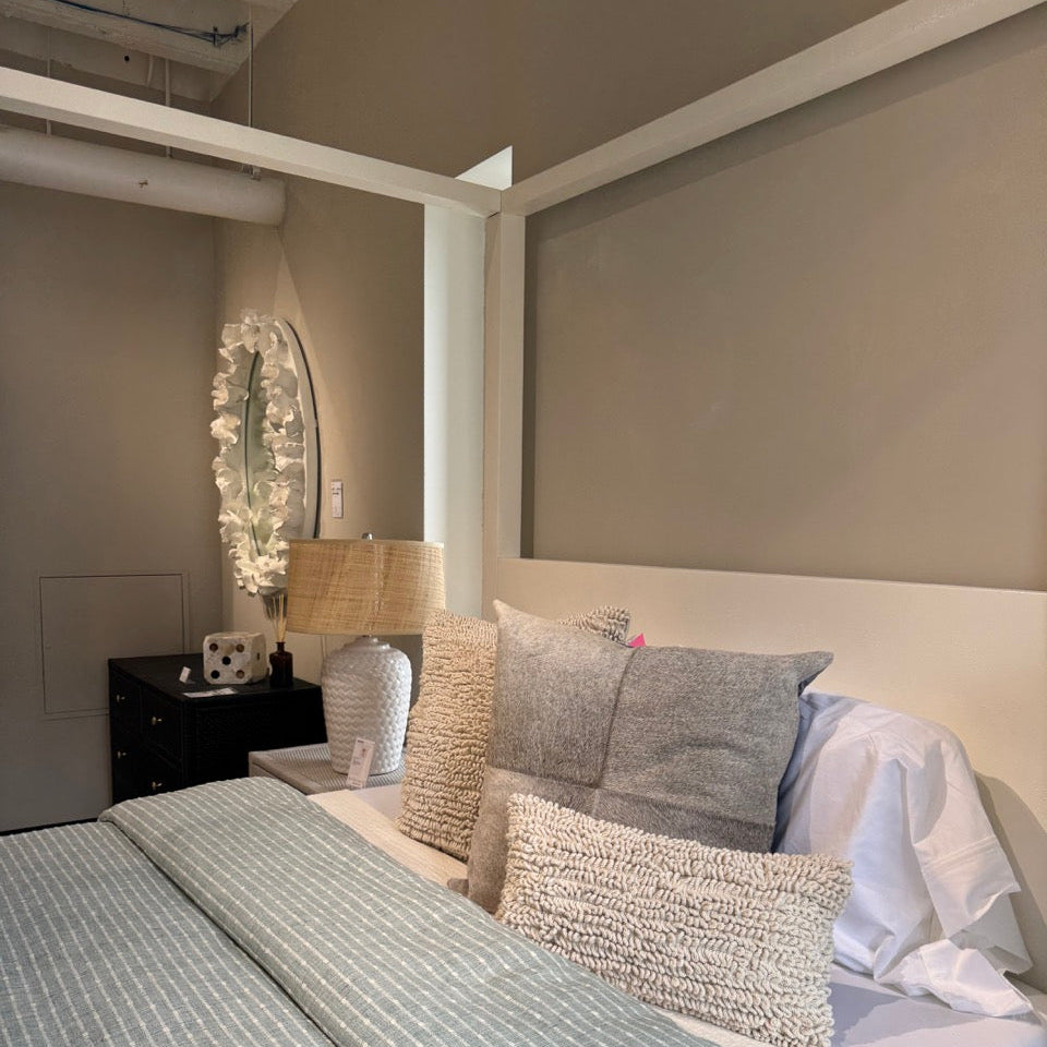 Neatly made bed with decorative pillows in a bedroom setting.