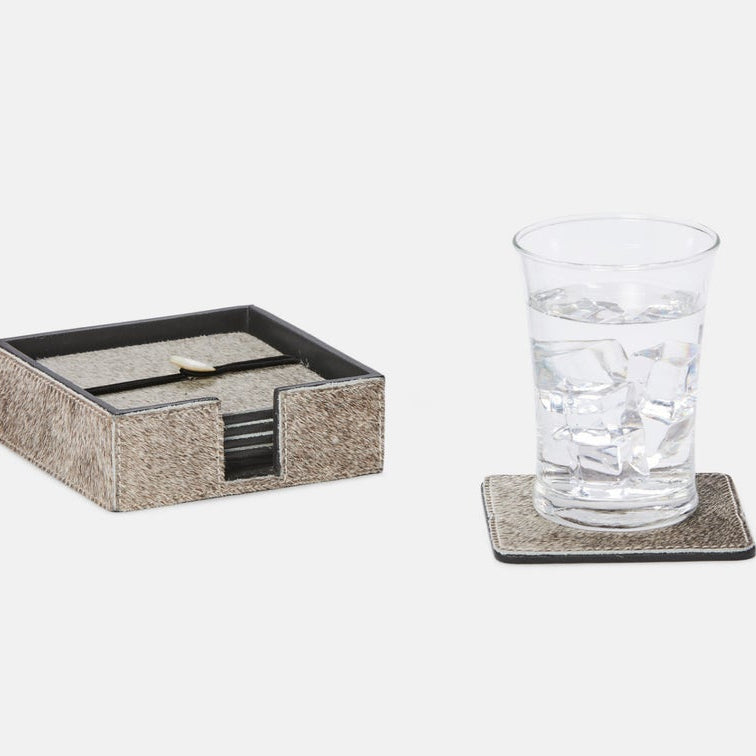 A square coaster set with a textured beige and brown animal-print pattern and black trim, shown with a glass of water and ice on one coaster and a matching box of coasters on a light gray background.