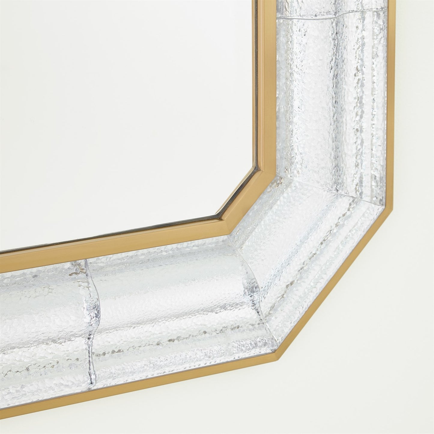 Close-up of a decorative mirror with a marble-like frame on a white background