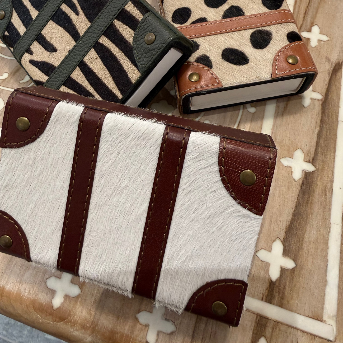 Three patterned wallets on a textured surface