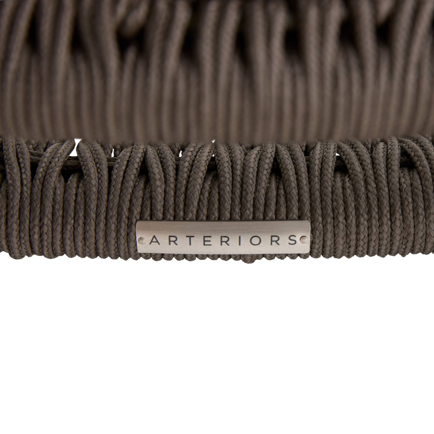 Close-up of a brown woven chair with 'Arteriors' branding on a white background