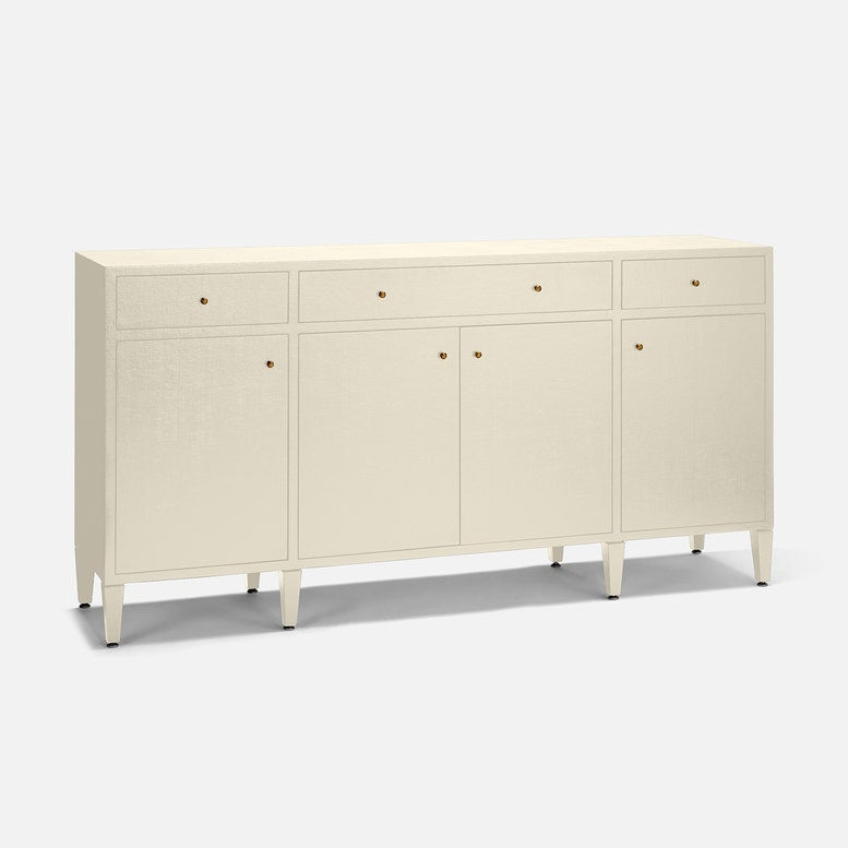 An off-white linen-textured sideboard cabinet with three drawers on top, two doors in the center, and four legs, accented with small gold knobs, shown on a light gray background.