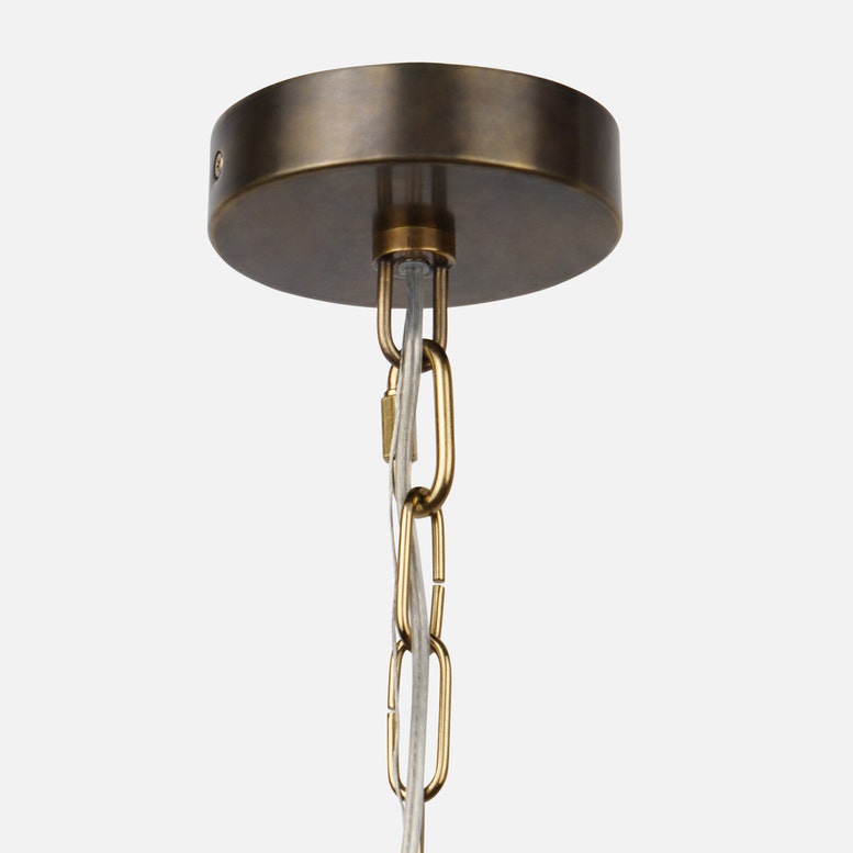 Brass ceiling light fixture with chain on a white background