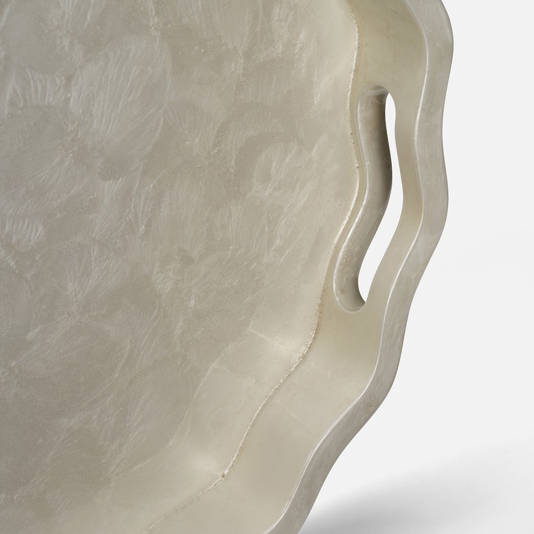 Two white ceramic trays with textured edges handle