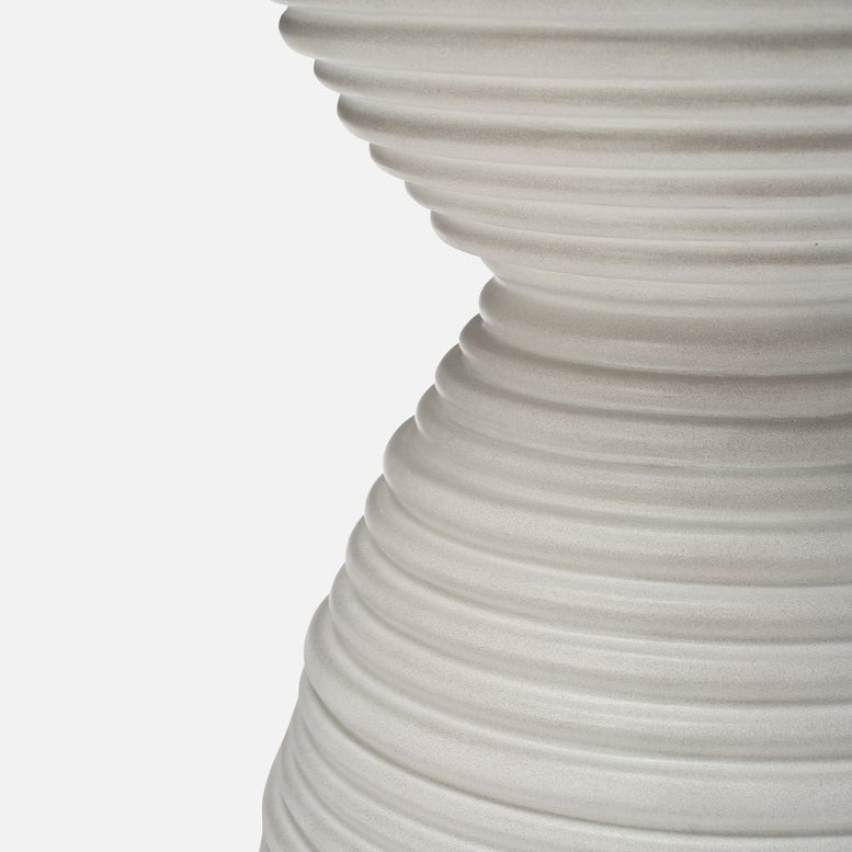 Close-up of a textured white vase on a light gray background