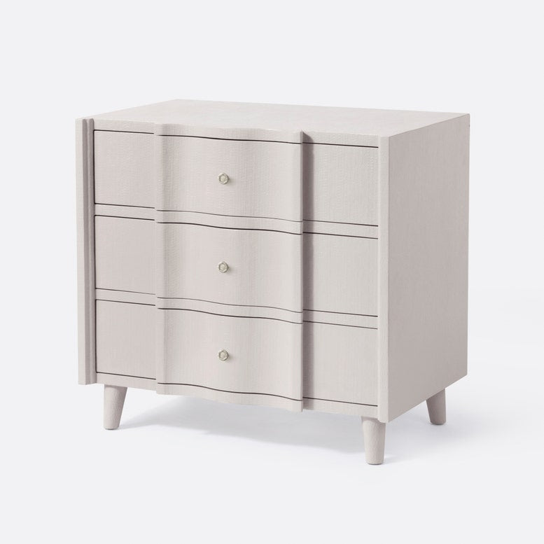 Beige dresser with three drawers on a white background