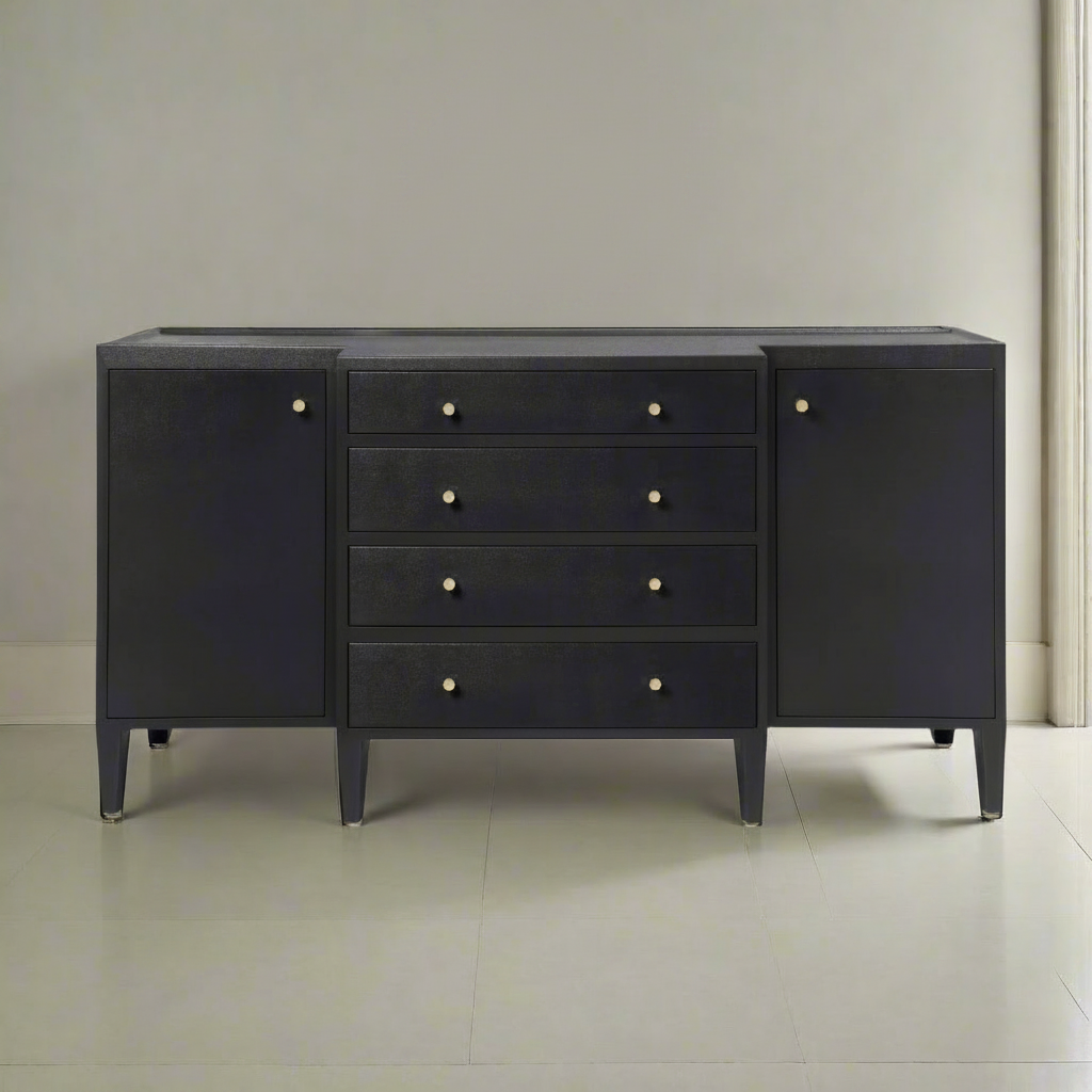 A modern dark blue-gray sideboard or dresser with five drawers in the center, flanked by two cabinet doors, featuring small round brass knobs and tapered legs, set against a neutral light gray wall and tiled floor.