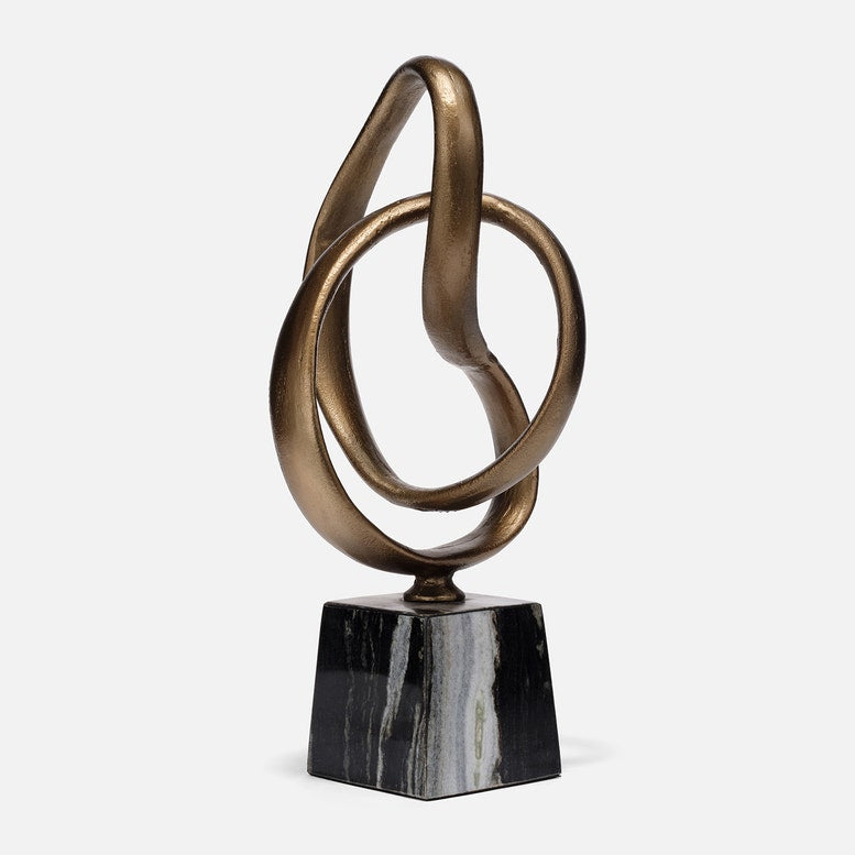 Bronze abstract sculpture on a black marble base against a white background