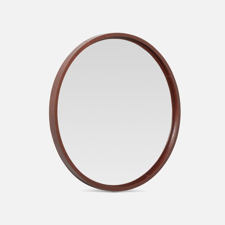 Round mirror with a leather frame on a white background