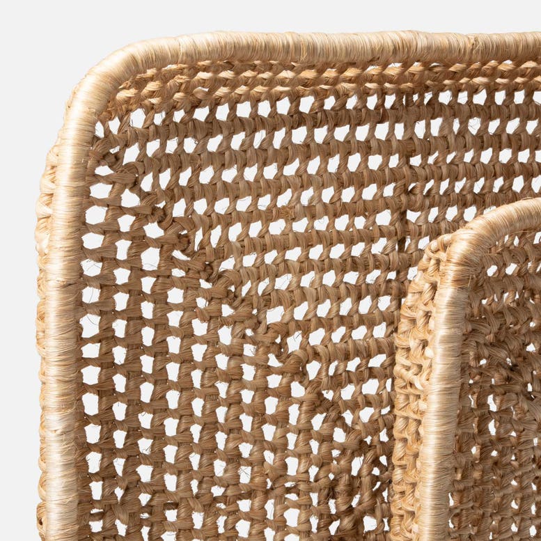 Close-up detail of a abaca tray showing the natural tan fiber texture and curved woven frame on a light gray background.