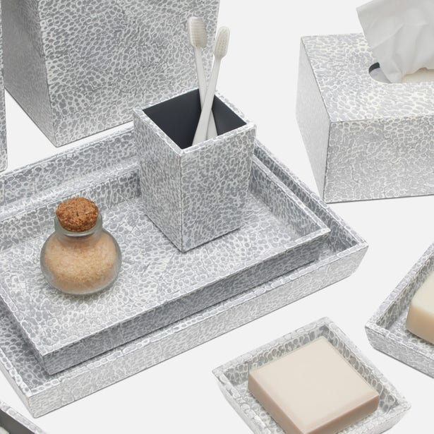 Bathroom accessories set with textured gray containers on a white background