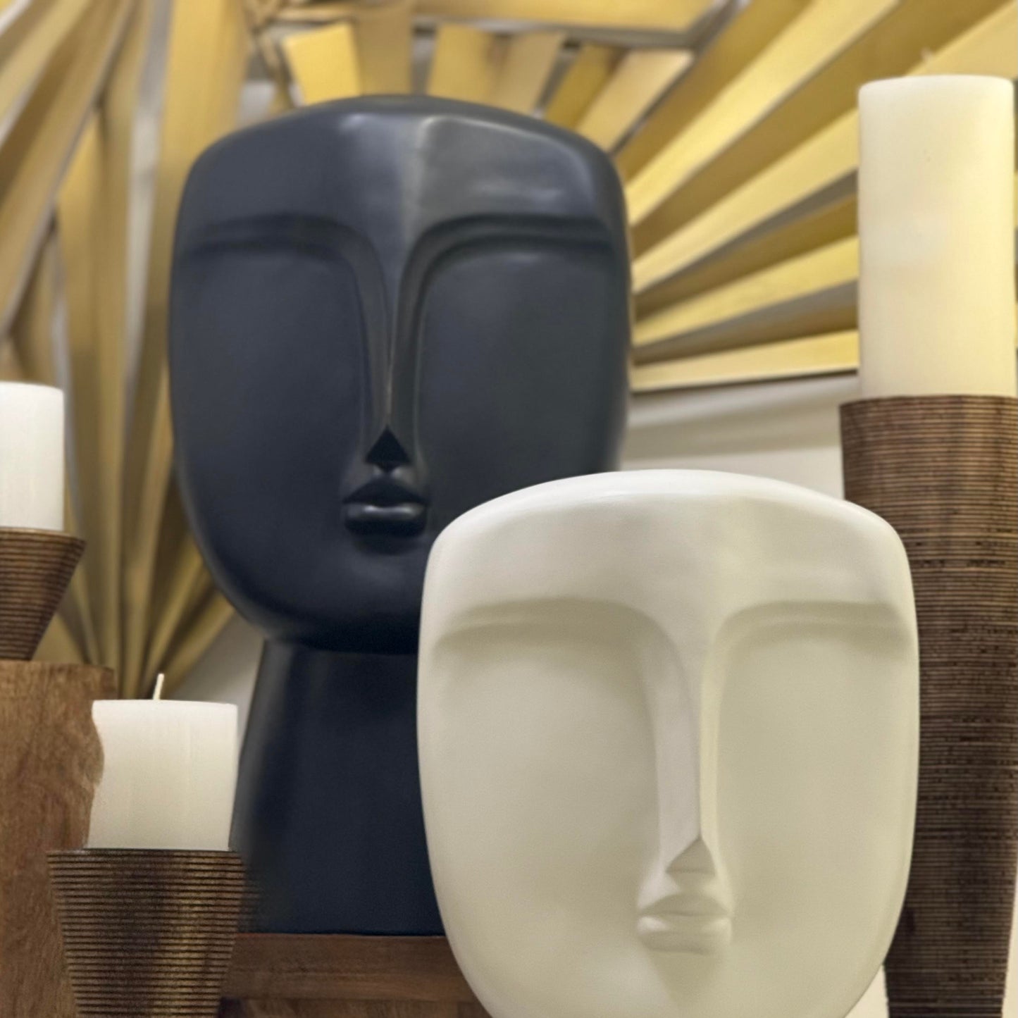 Decorative head sculptures with candles on a shelf