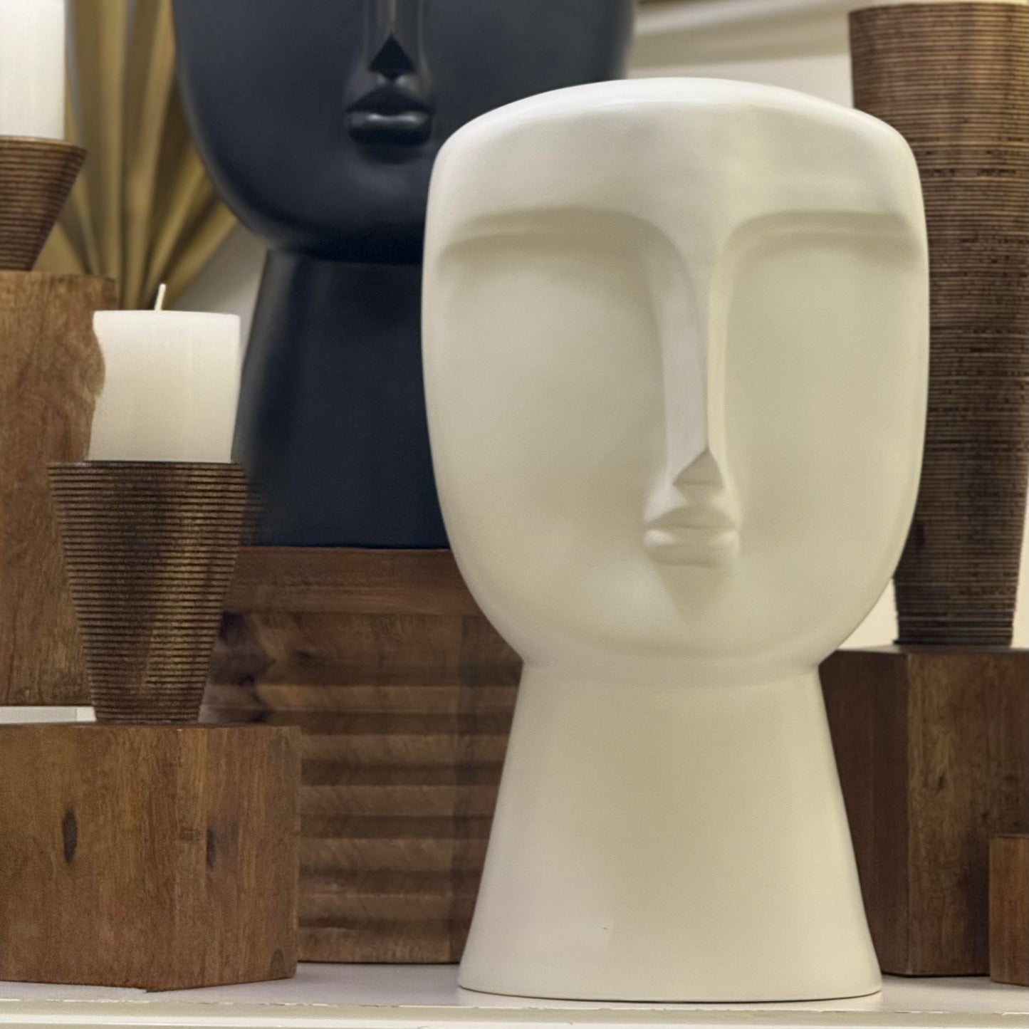 Decorative head sculptures with candles on a shelf