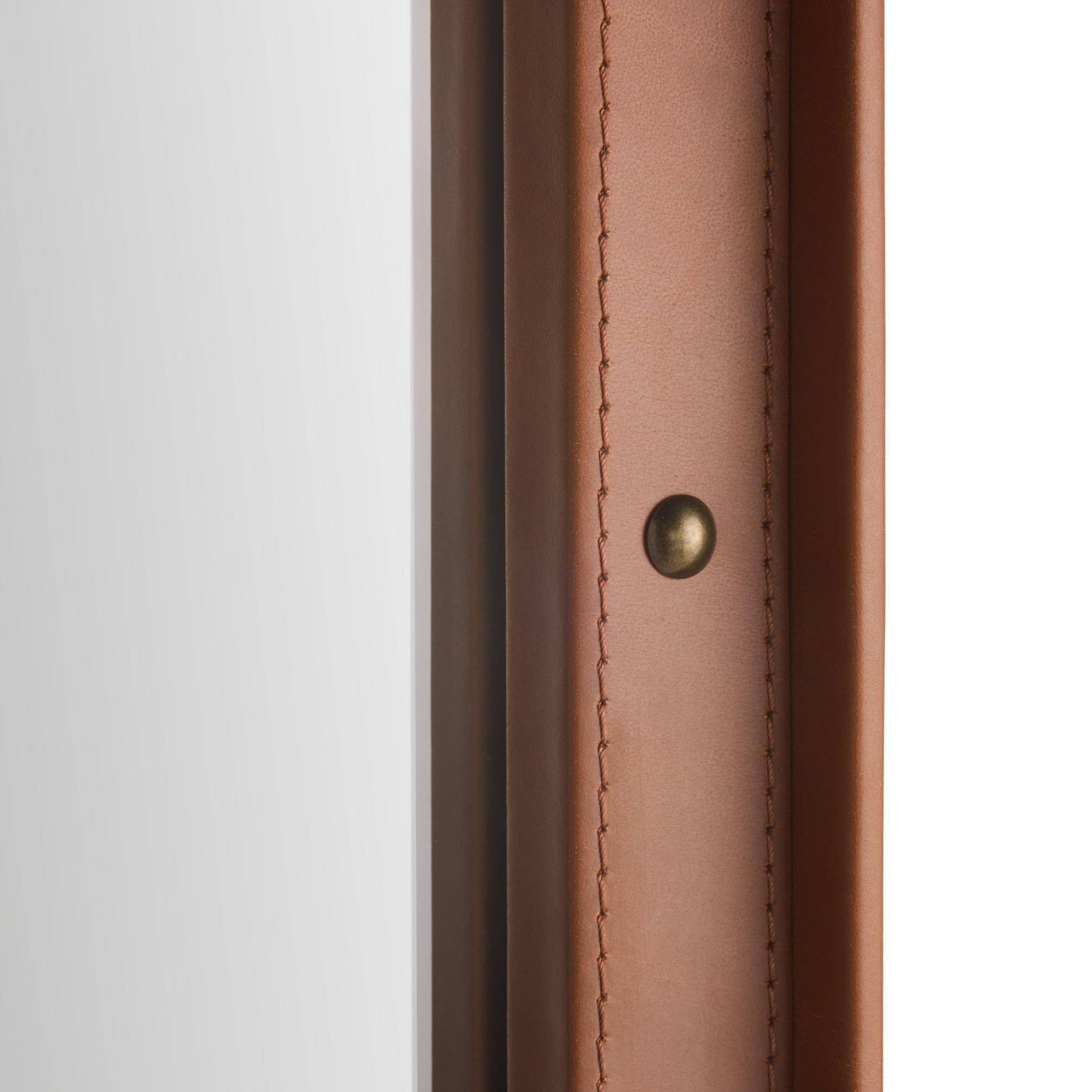 Close-up detail of a brown leather or faux-leather trim piece with visible stitching and a small round brass-toned rivet, set against a white background.