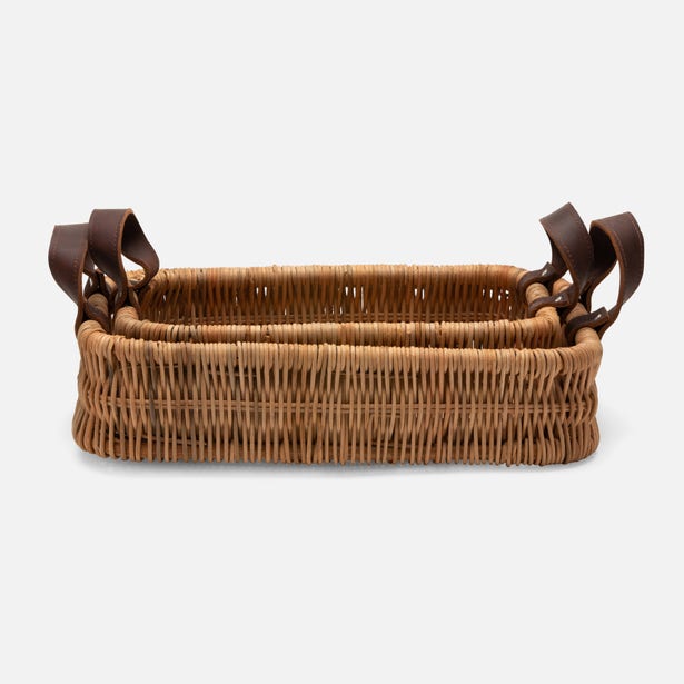 Wicker basket with leather handles on a white background