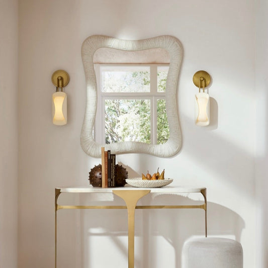 ivory curved sconces with a white mirror and console