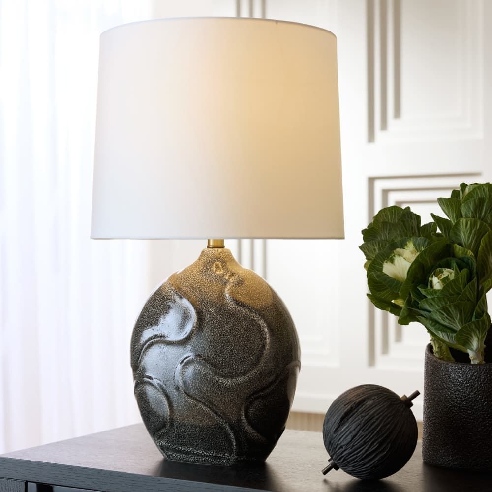 this table lamp by arteriors home features an organic porcelain silhouette with textured obsidian reactive glaze reminiscent of coral formation 