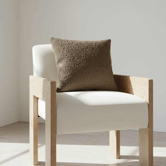 cerused oak chair upholstered in white polyester with a brown textured pillow on top