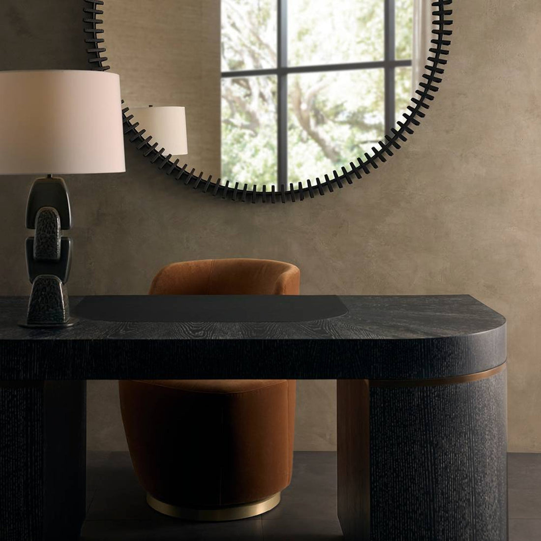 table lamp on a desk with a swivel chair and round mirror