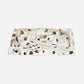 A rectangular resin tray with a textured, organic pattern of black, brown, and beige spots on a translucent white base, photographed on a light gray background.