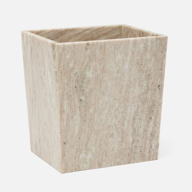 A square wastebasket made from light beige marble with natural veining, shown on a plain light gray background.