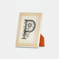 Framed artwork with a decorative letter 'P' on a white background