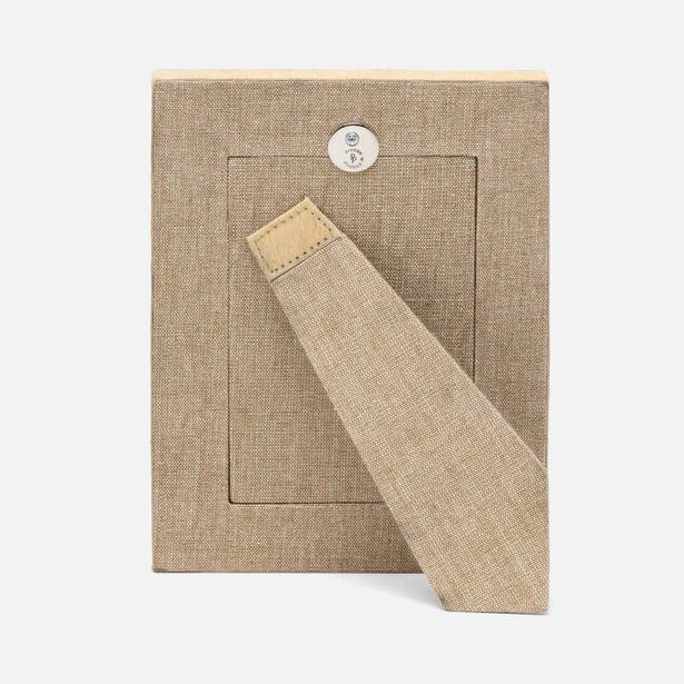 Beige fabric bookmark with a button on a matching fabric background