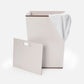 White laundry basket with a white towel on a white background
