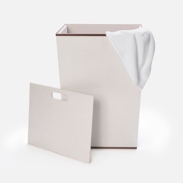 White laundry basket with a white towel on a white background