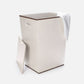 Beige laundry basket with a white towel on a white background