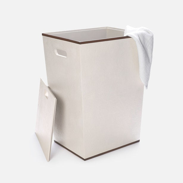 Beige laundry basket with a white towel on a white background