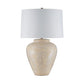 Table lamp with a textured beige base and white shade on a white background