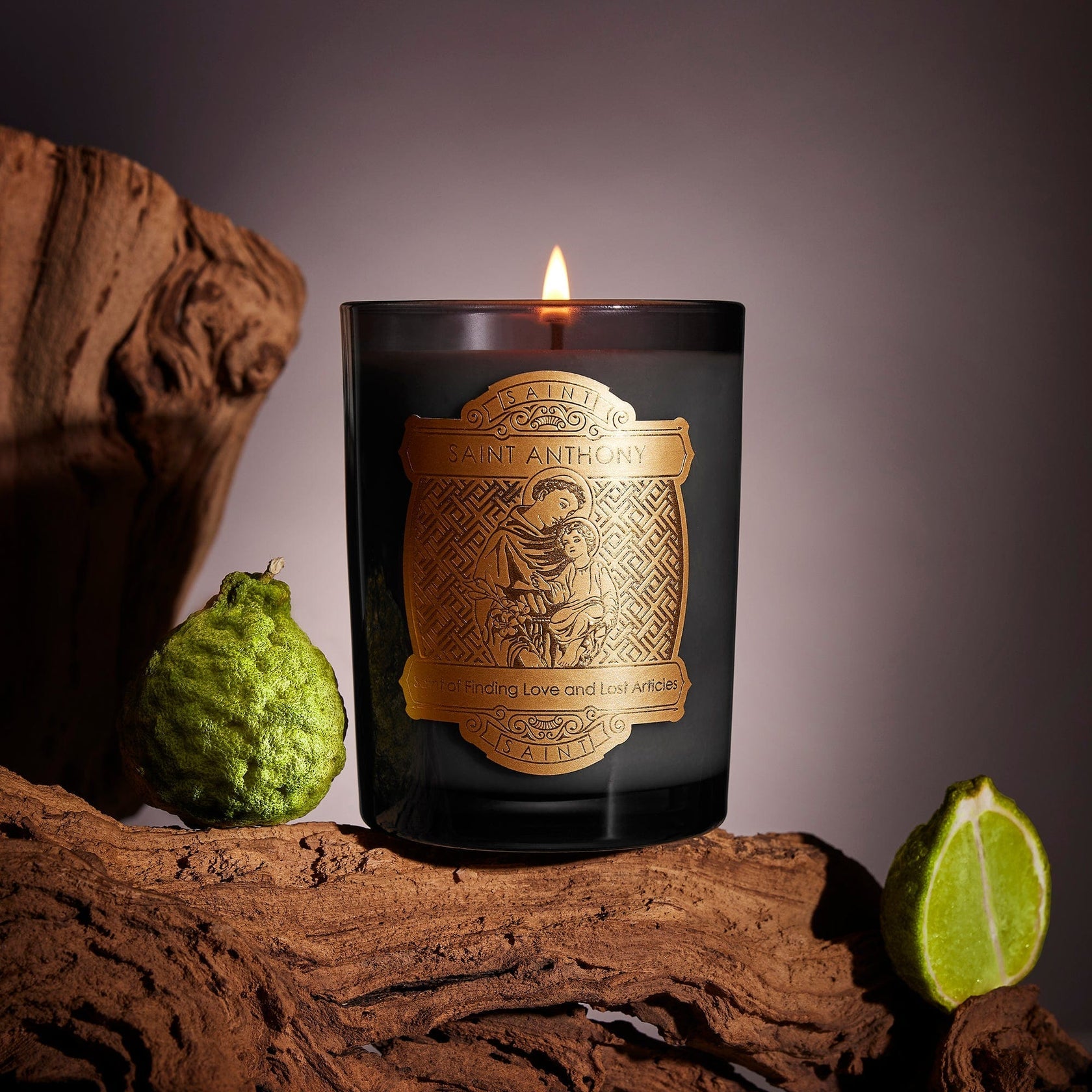 Candle with a decorative label on a wooden surface with limes