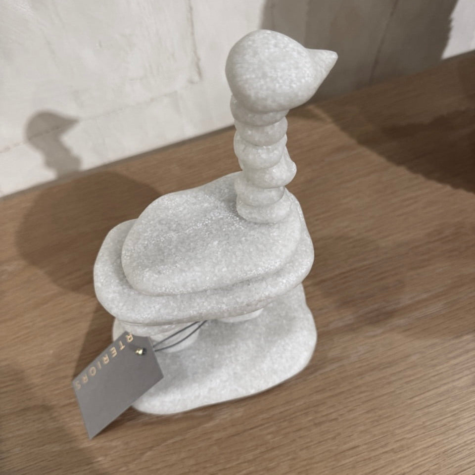 Gray stone sculpture on a wooden surface with a blurred background