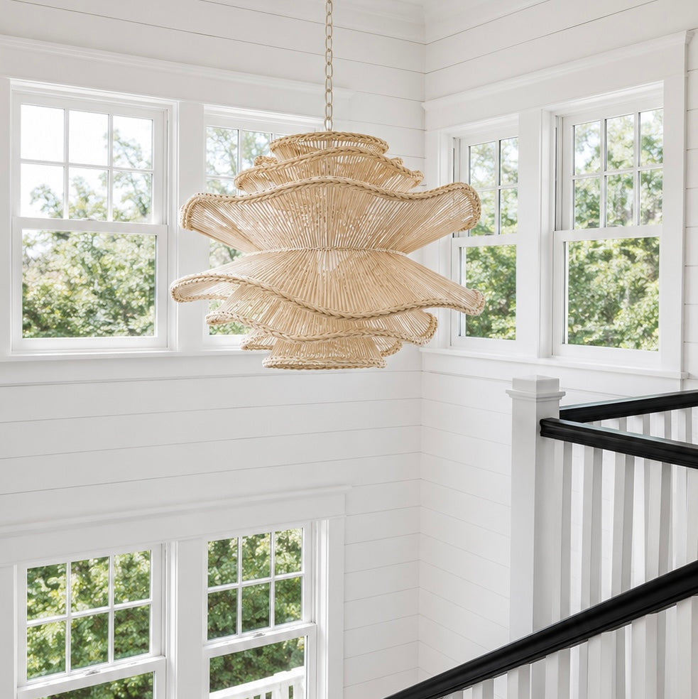 Chandelier hanging in a room with large windows and a staircase