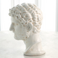 White marble bust of a classical figure on a light background