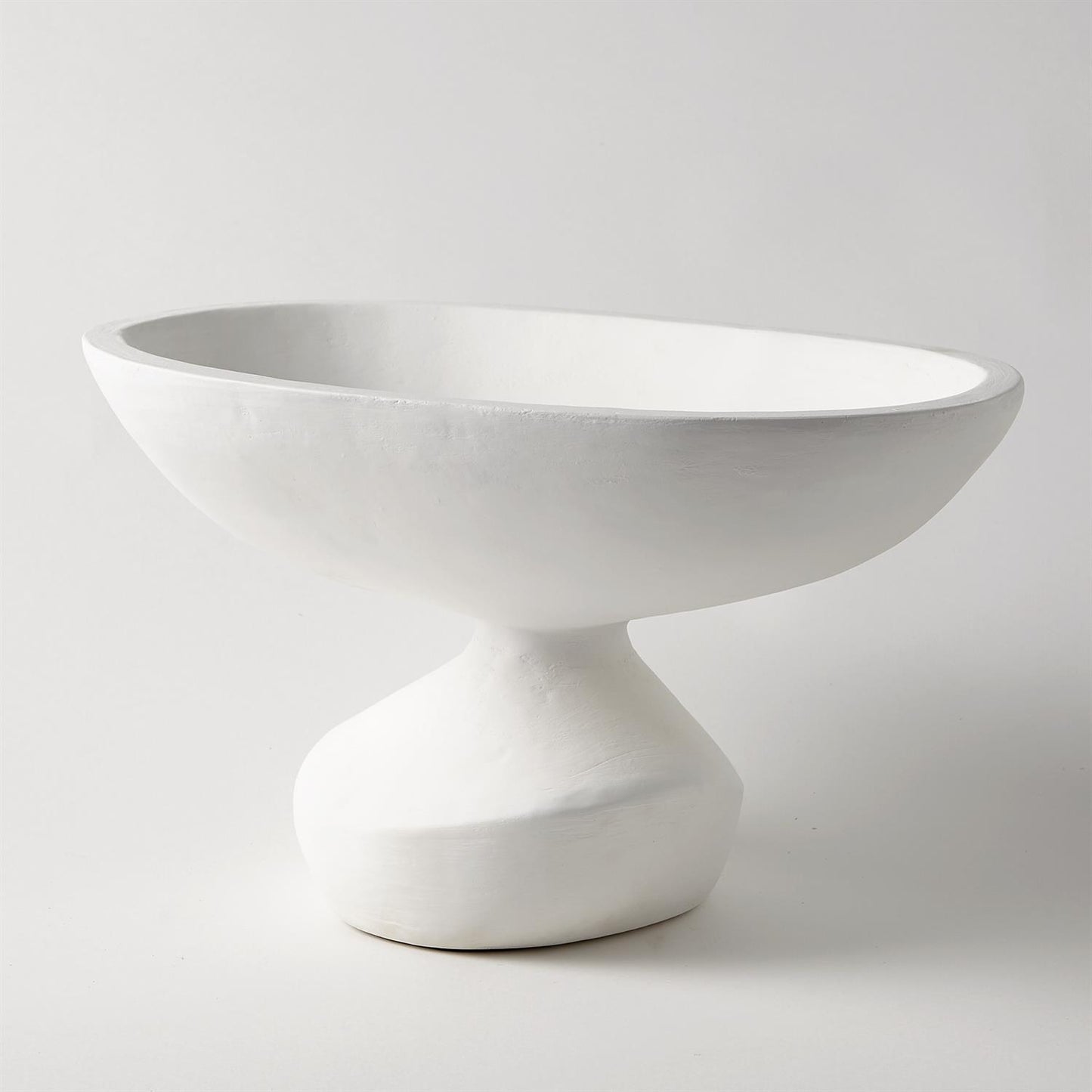 White ceramic bowl on a pedestal against a light gray background