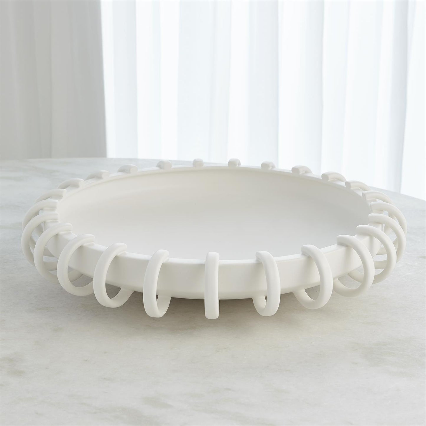 White decorative bowl with a unique spiral design on a white surface.