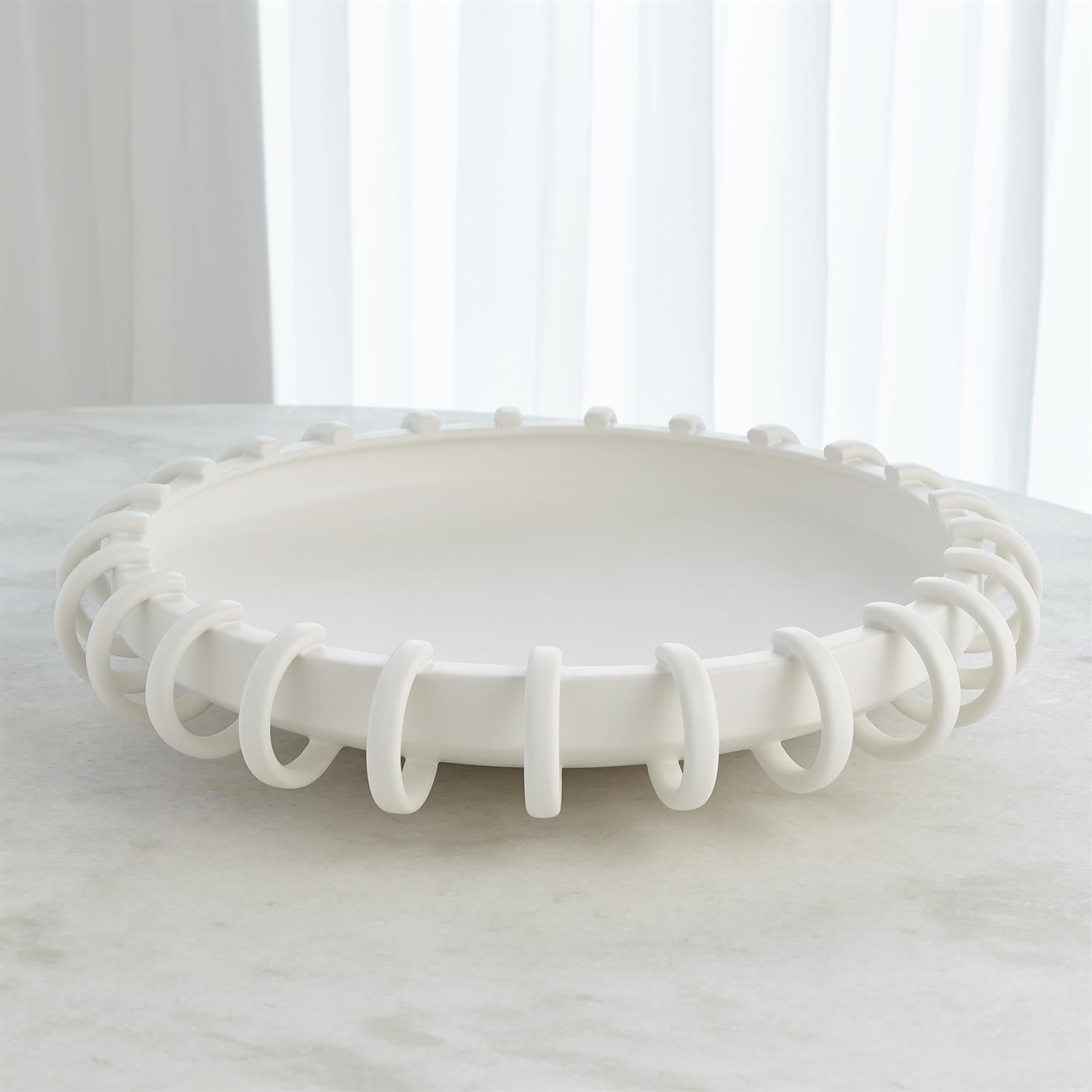White decorative bowl with a unique spiral design on a white surface.