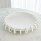White decorative bowl with a unique design on a marble surface