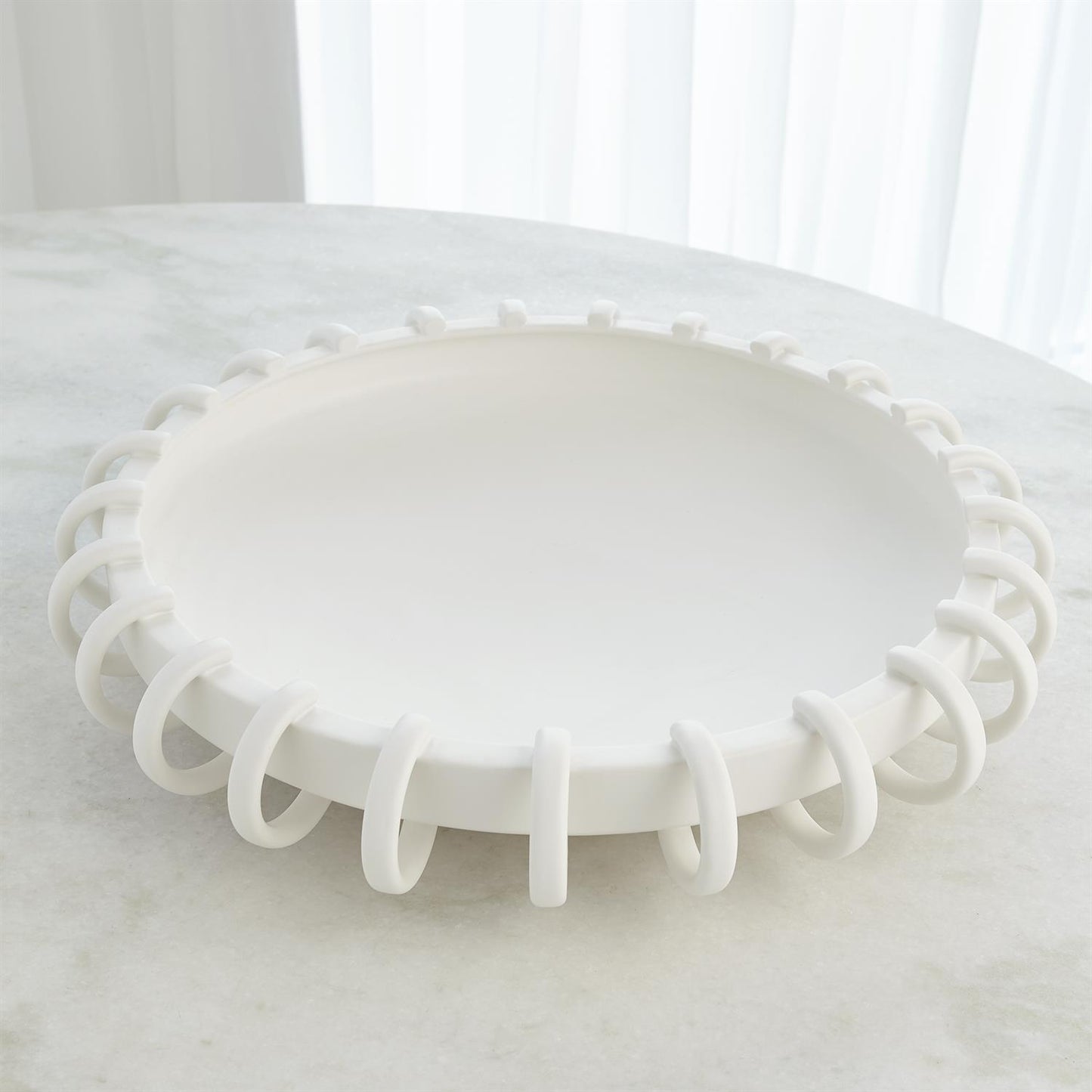 White decorative bowl with a unique design on a marble surface