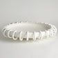 White ceiling light fixture with decorative design on a gray background