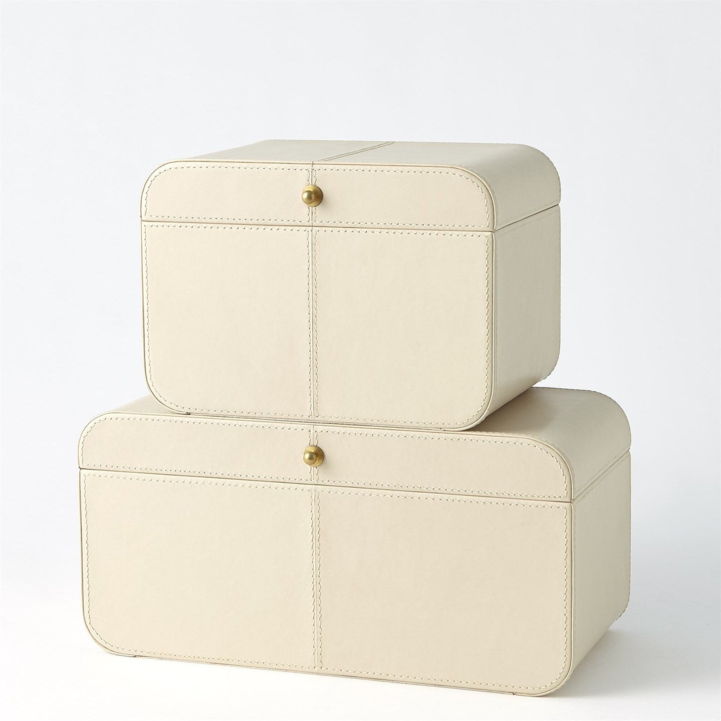 Two cream-colored jewelry boxes with gold accents on a white background