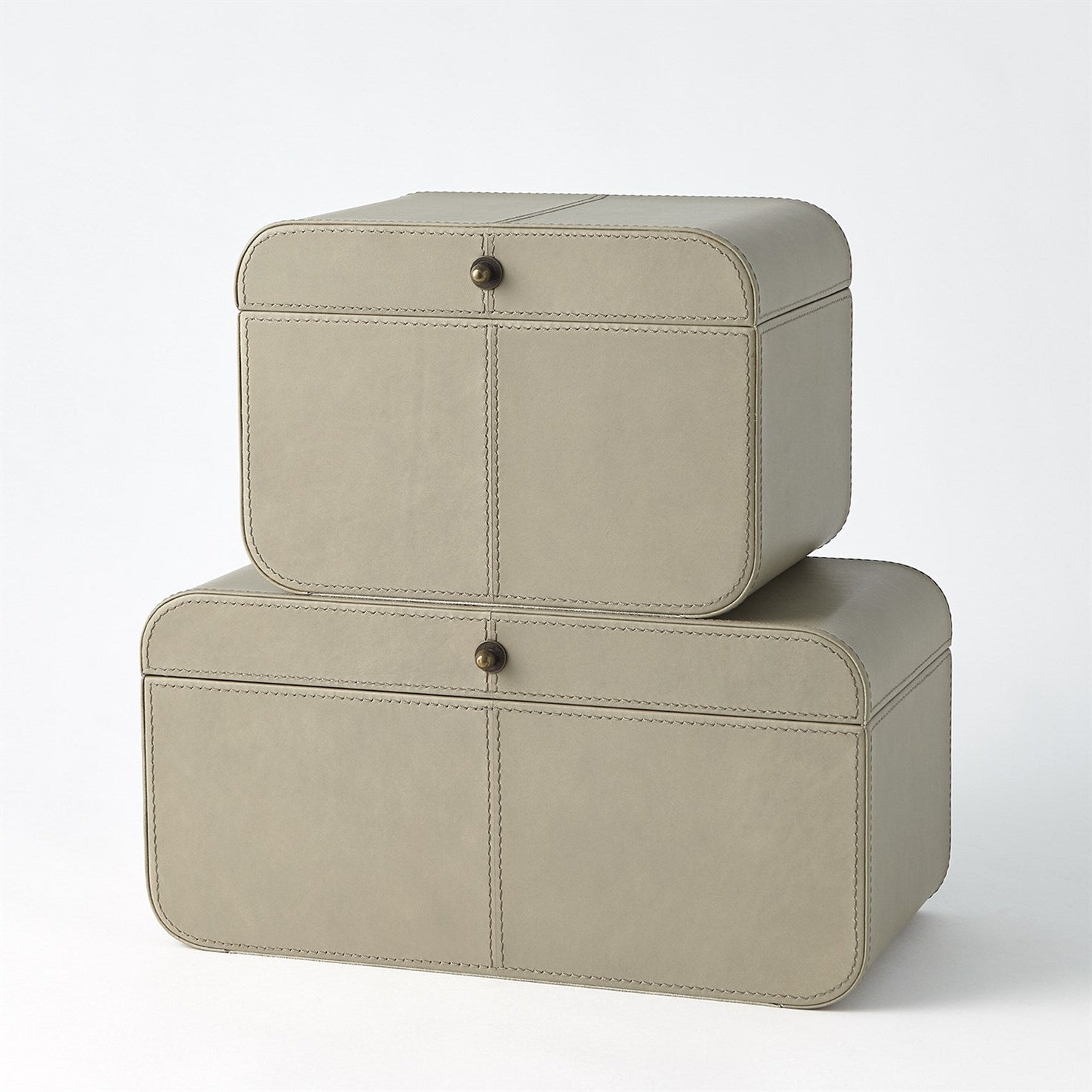 Two beige leather storage boxes stacked on a white background