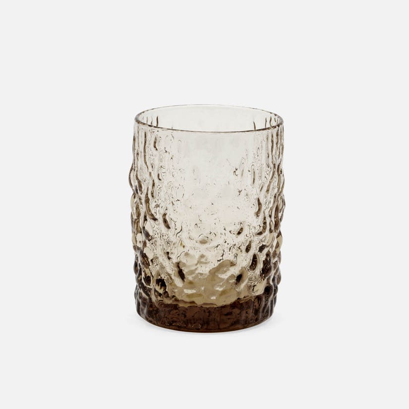 Textured glass tumbler on a white background