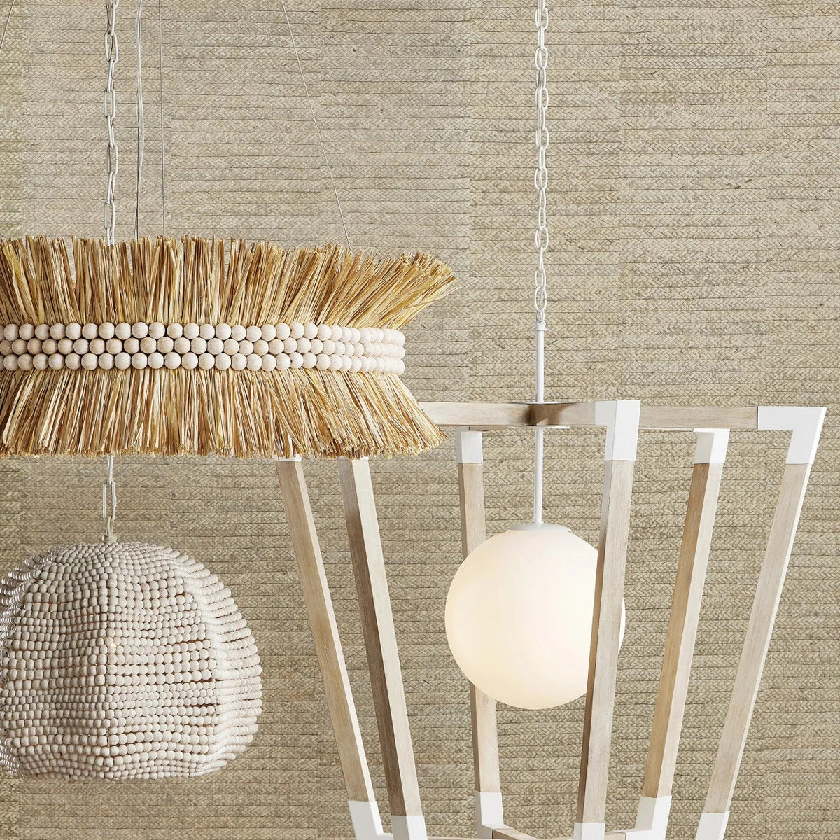 Modern pendant light with decorative elements against a textured beige wall.