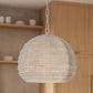 Beaded pendant light hanging in a kitchen setting with wooden cabinets and shelves.