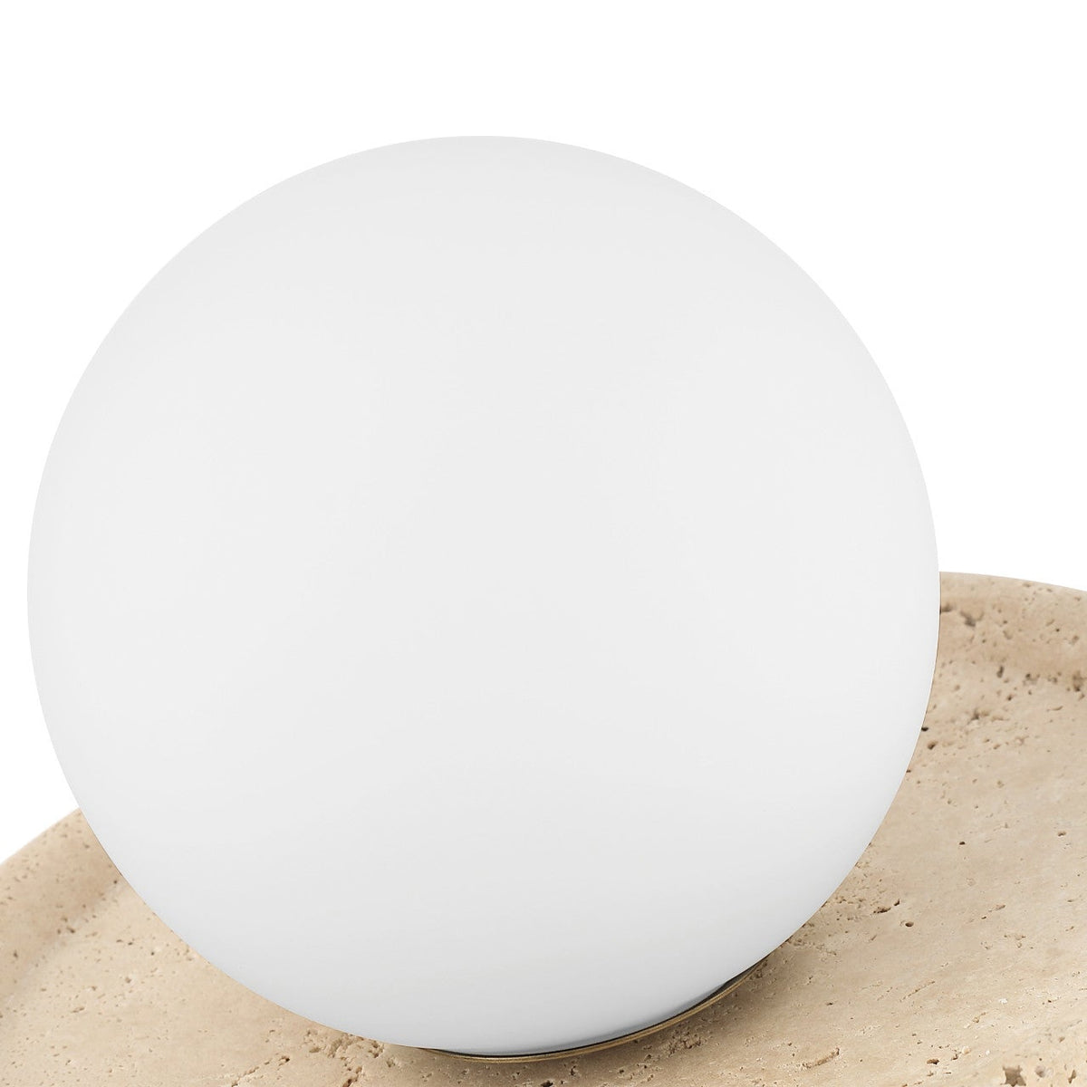 White spherical object on a beige surface with a white background